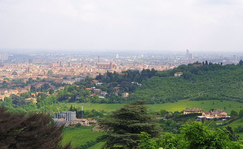 Panoramablick von den Hügeln bei San Luca über das rote Dächermeer und die historischen Türme von Bologna.