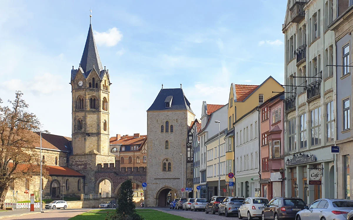 Blick auf das historische Nikolaitor und den Turm der Nikolaikirche am Karlsplatz in Eisenach mit angrenzender Häuserzeile.