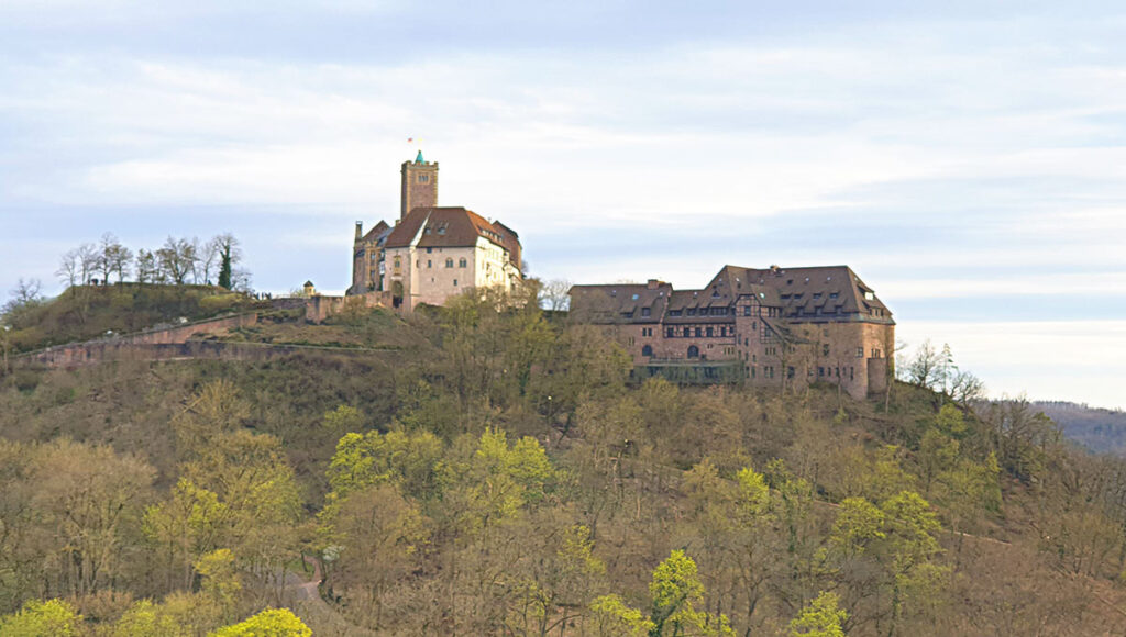 Panoramablick vom Aussichtspunkt Metilstein auf die hoch über den Wäldern thronende Wartburg bei Eisenach.