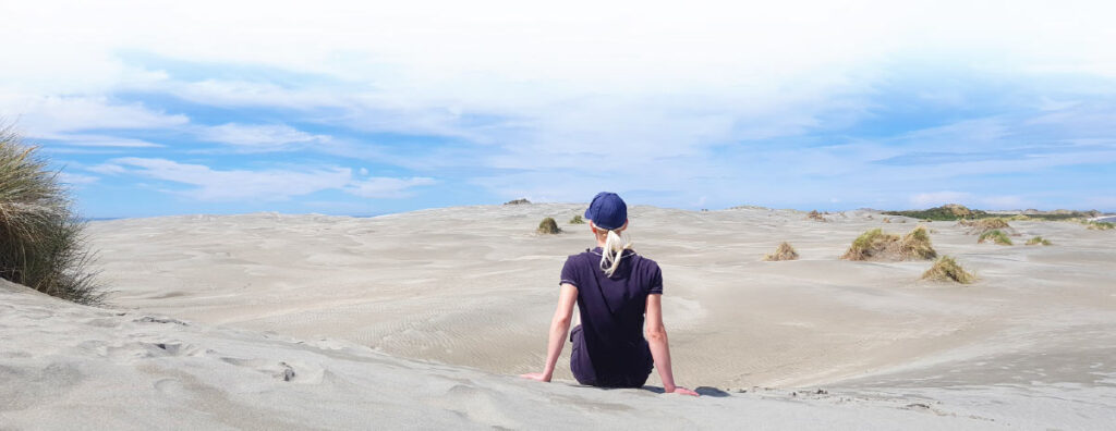 Reisende blickt über die Dünenlandschaft von Farewell Spit in Neuseeland.