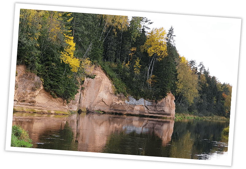 Spiegelung der bewaldeten Sandsteinfelsen am Ufer des Flusses Gauja im Gauja-Nationalpark, Lettland.