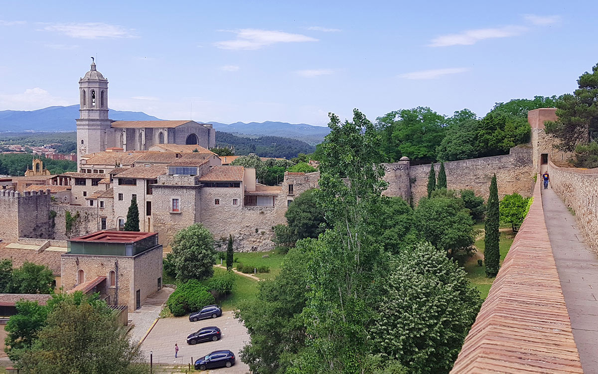 Aussicht von der historischen Stadtmauer (Passeig de la Muralla) auf die Dächer der Altstadt und die Kathedrale von Girona.