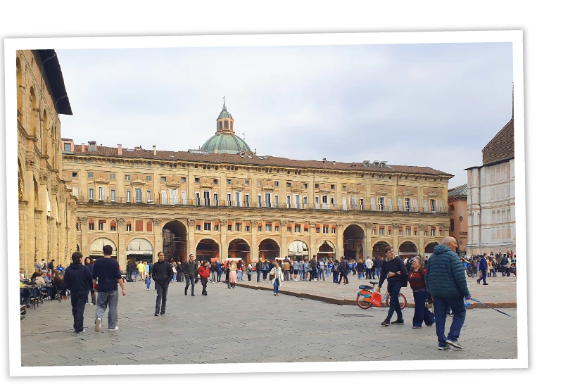 Foto der Piazza Maggiore in Bologna mit dem Palazzo dei Banchi und der Kuppel des Santuario di Santa Maria della Vita im Hintergrund – Link zum Bologna-Reisebericht.