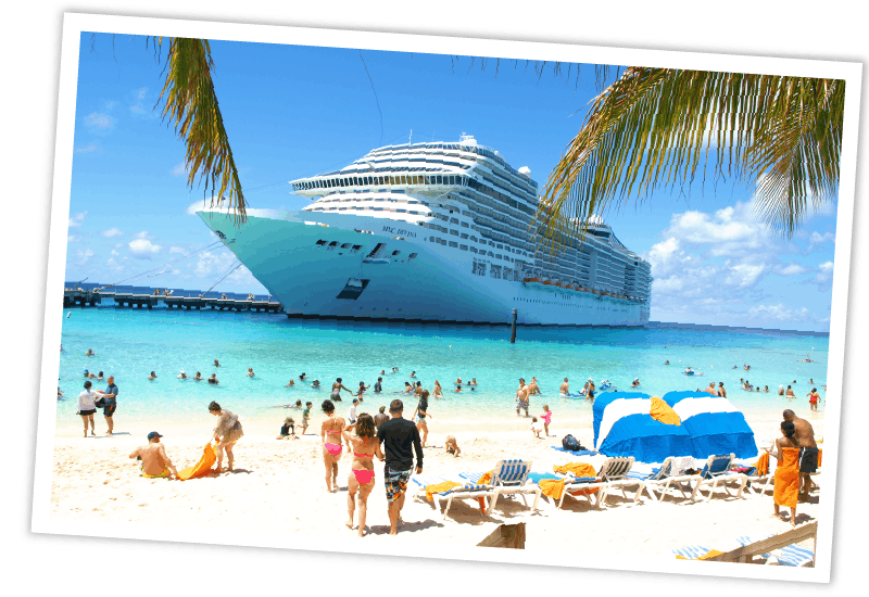 Ein großes Kreuzfahrtschiff liegt vor einem sonnigen Sandstrand mit türkisblauem Wasser vor Anker, während Badegäste im Vordergrund entspannen.