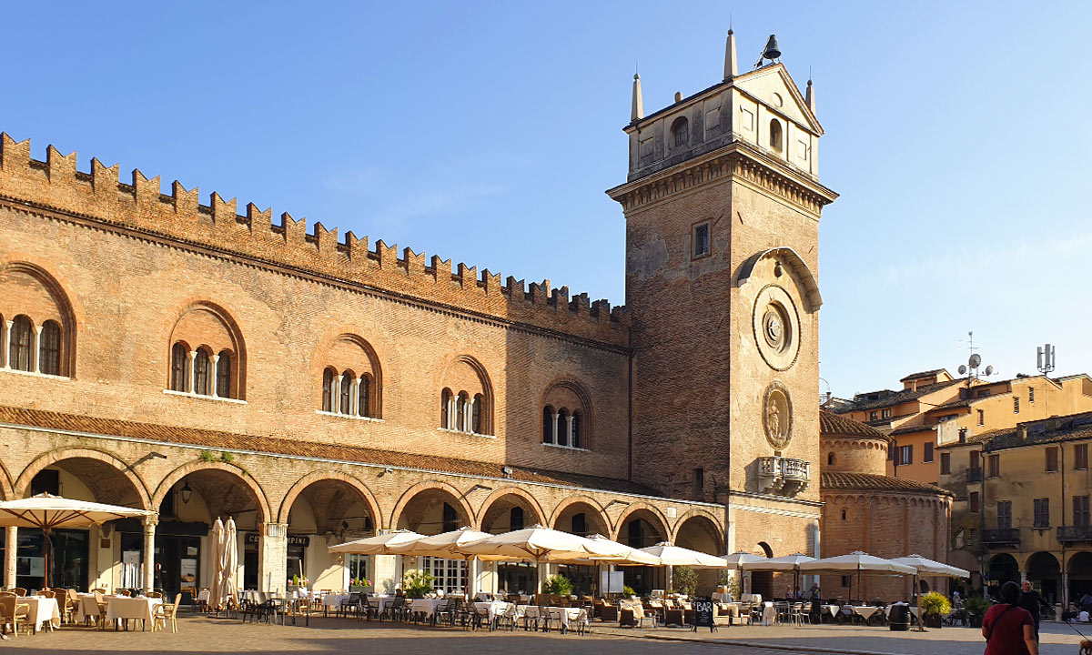 Der historische Piazza delle Erbe in Mantua mit dem Palazzo della Ragione, dem Torre dell'Orologio und der Rotonda di San Lorenzo im Sonnenlicht