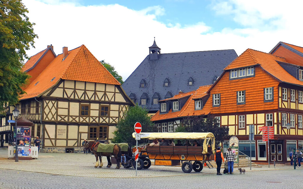 Das schiefe Fachwerkhaus in Wernigerode am Klint mit einer Pferdekutsche davor