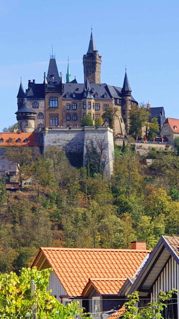Schloss Wernigerode thront auf einem bewaldeten Berg über den Hausdächern der Stadt