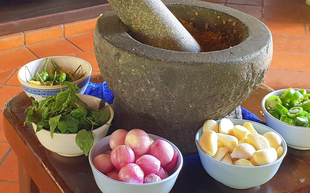 Zutaten und Mörser für die Herstellung von Thai Curry Paste in einer Kochschule auf Koh Lanta