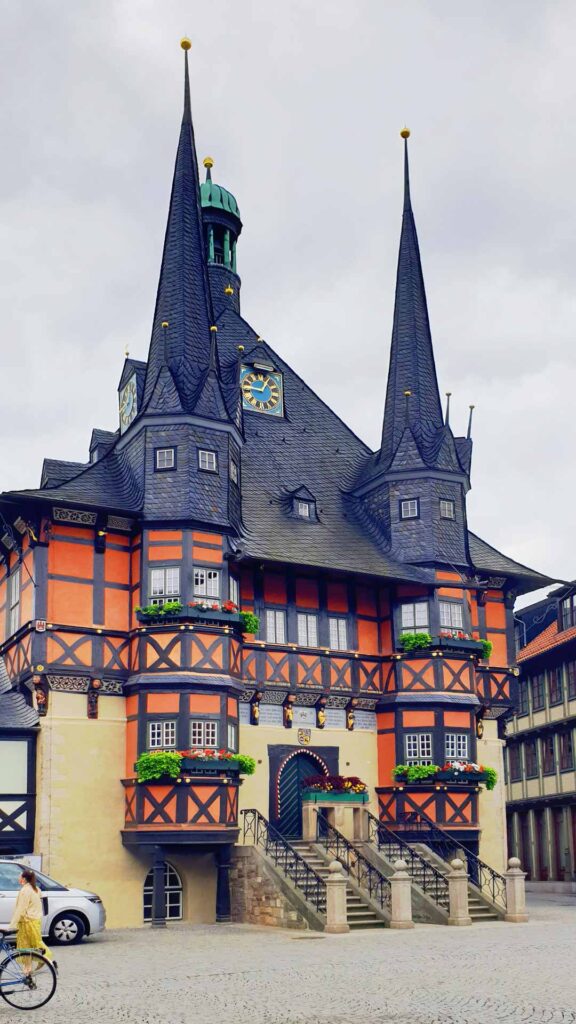 Das historische, rostrote Rathaus von Wernigerode mit spitzen Doppeltürmen, Erkern und Freitreppe am Marktplatz